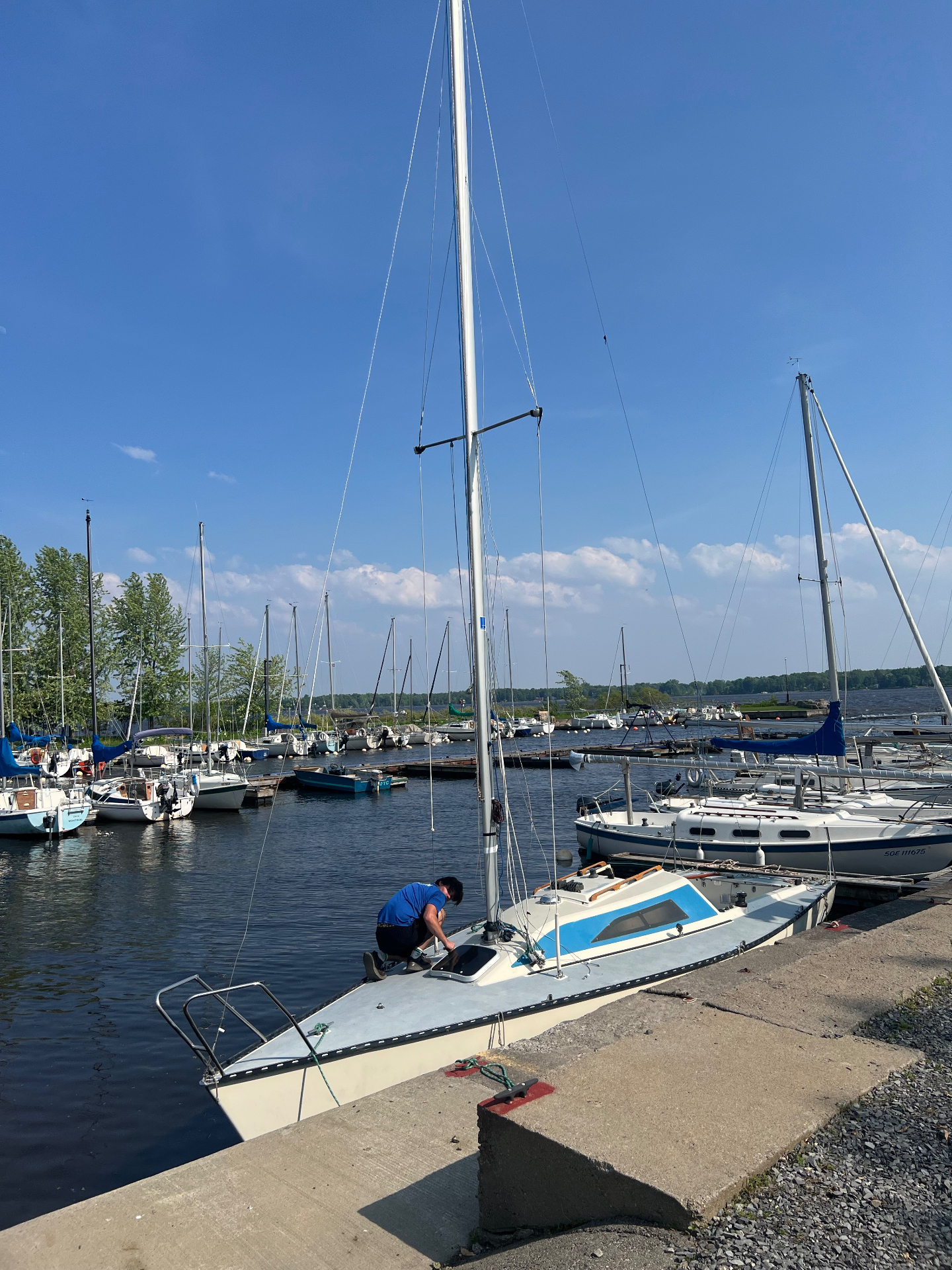 Eric Parkhill working on a sailboat at a West Island yacht club dock.