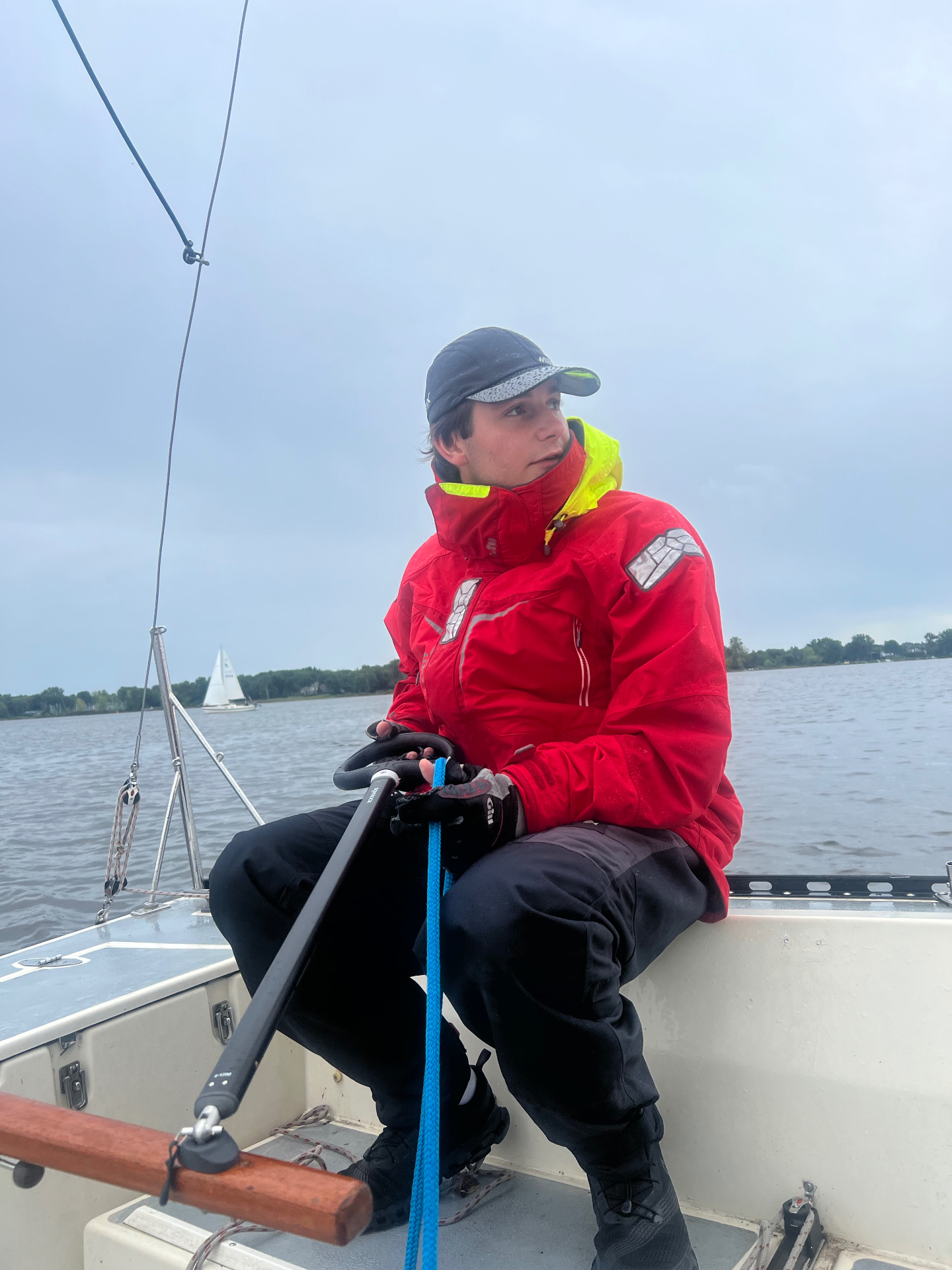 Eric Parkhill sailing on a boat wearing red foul-weather gear.